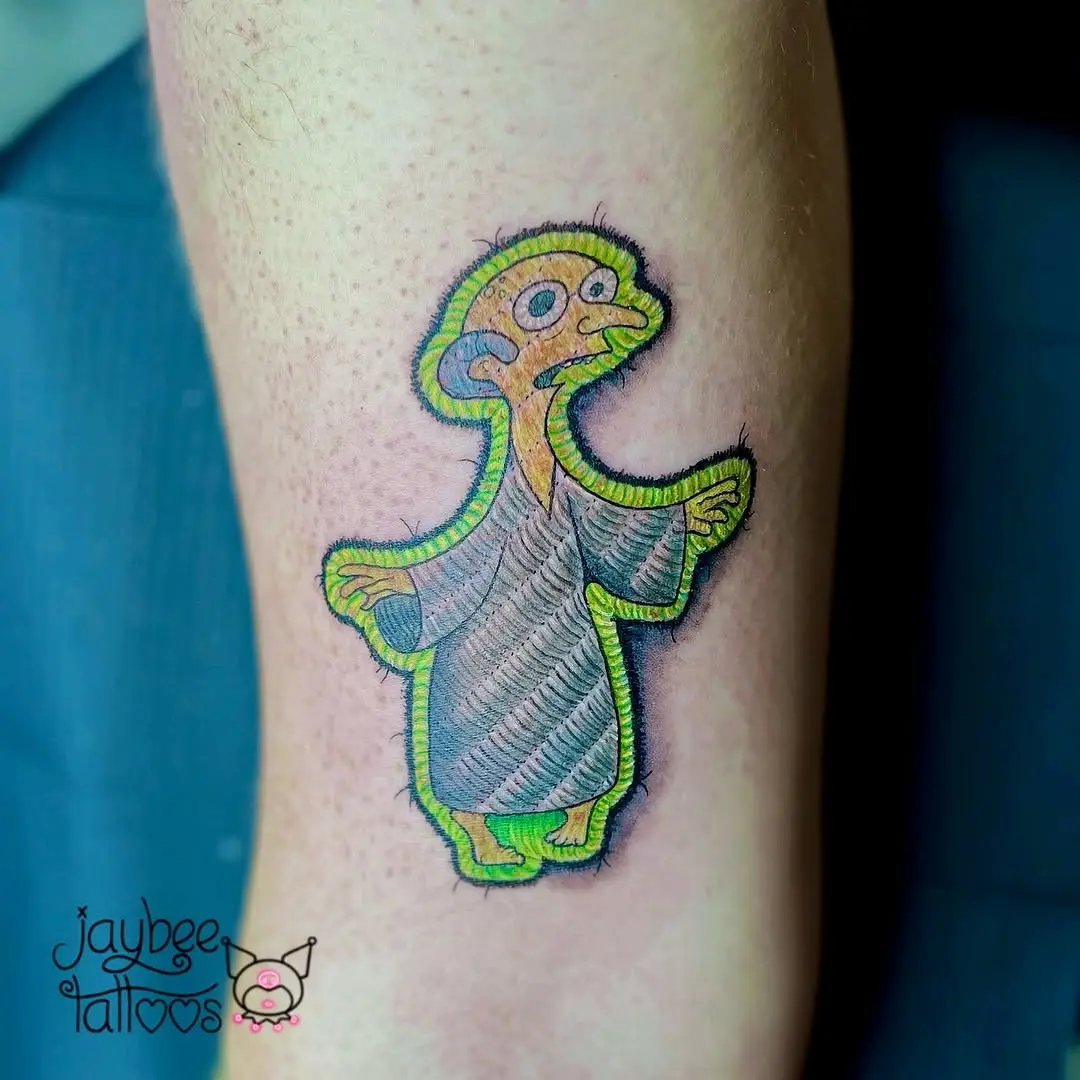 Playful embroidered character tattoo with vibrant hues