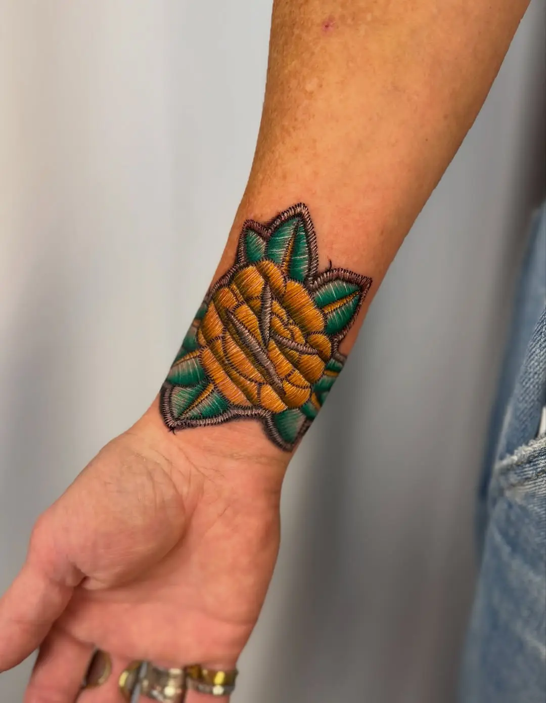 Stunning embroidery-style flower tattoo on wrist