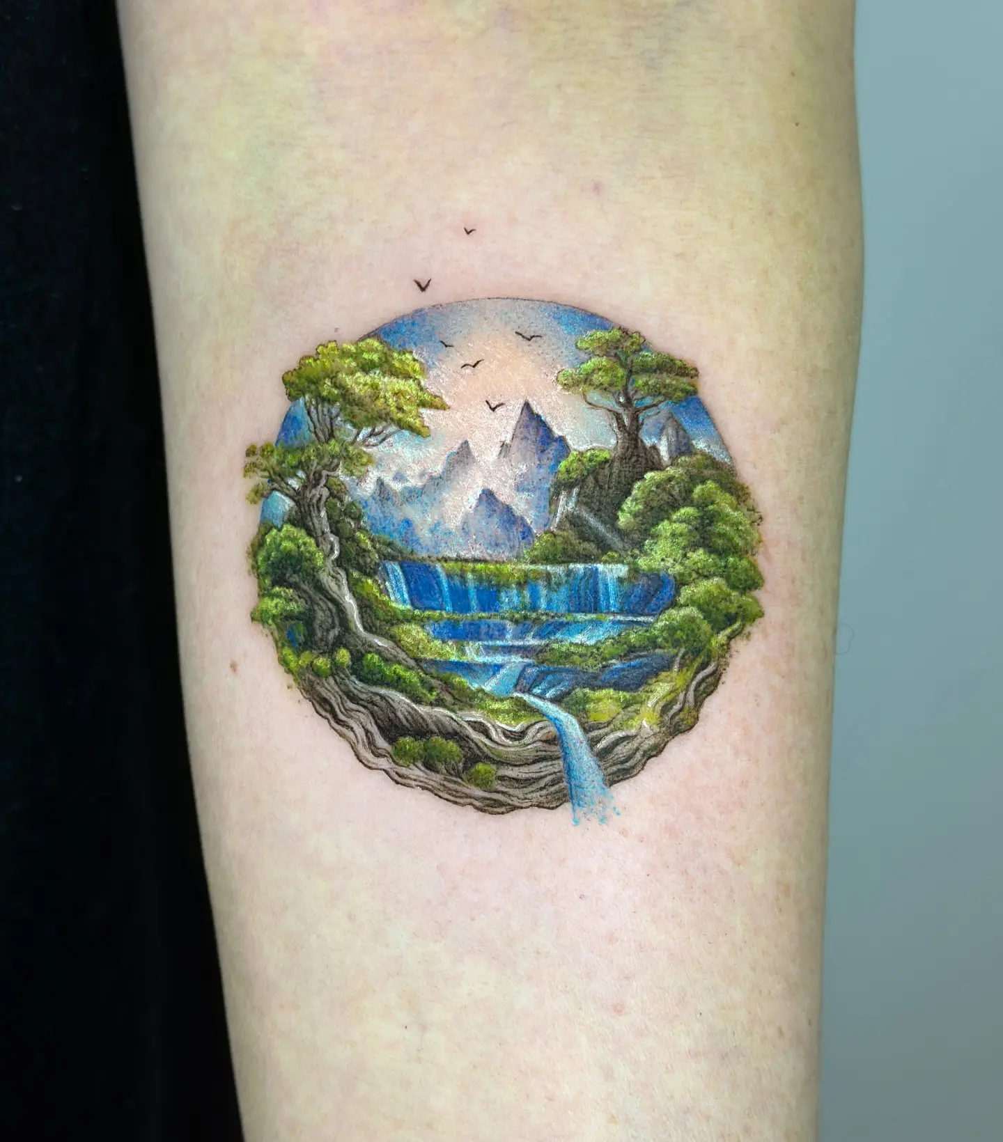Breathtaking nature scene in a globe tattoo