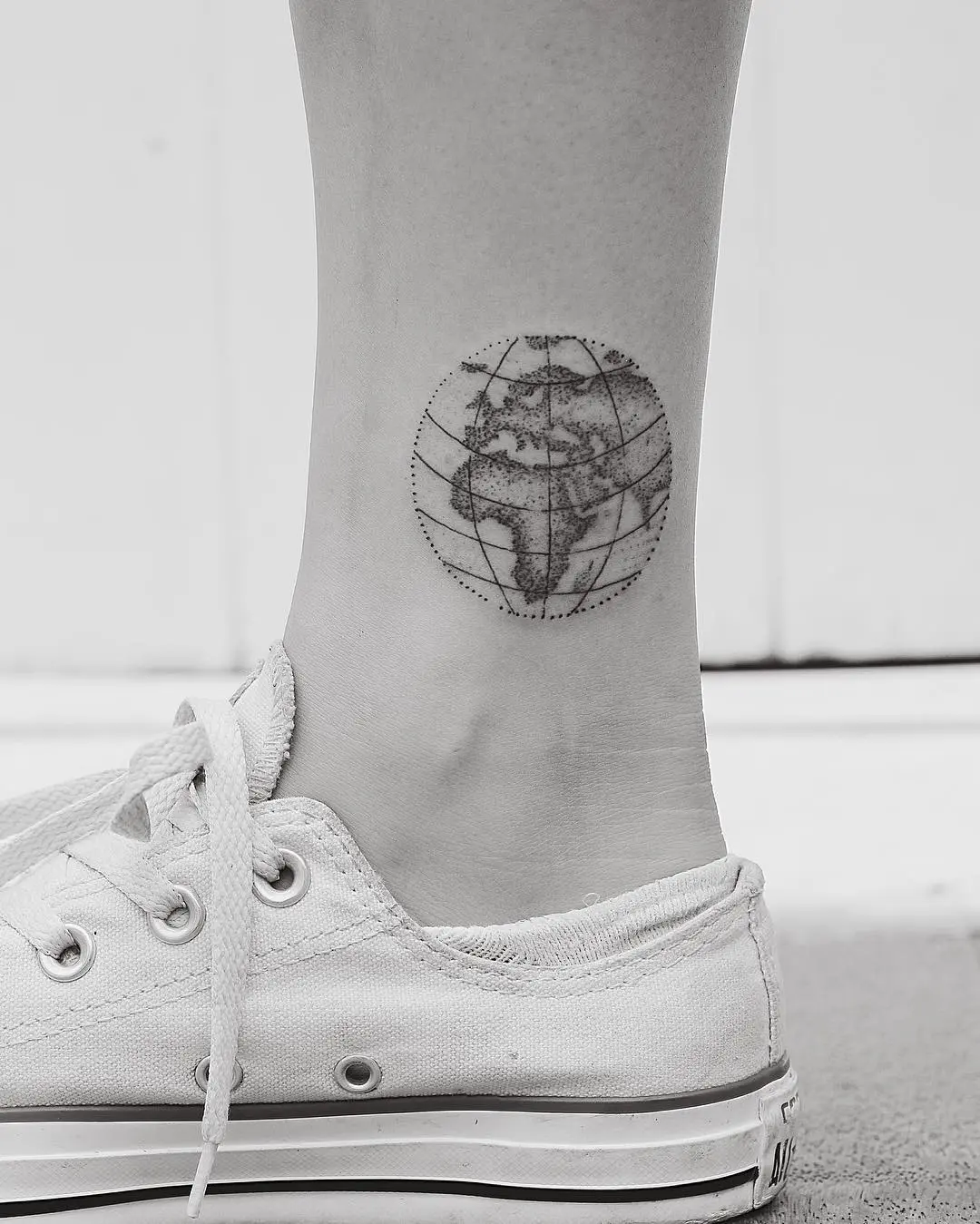 Minimalist globe tattoo on the ankle
