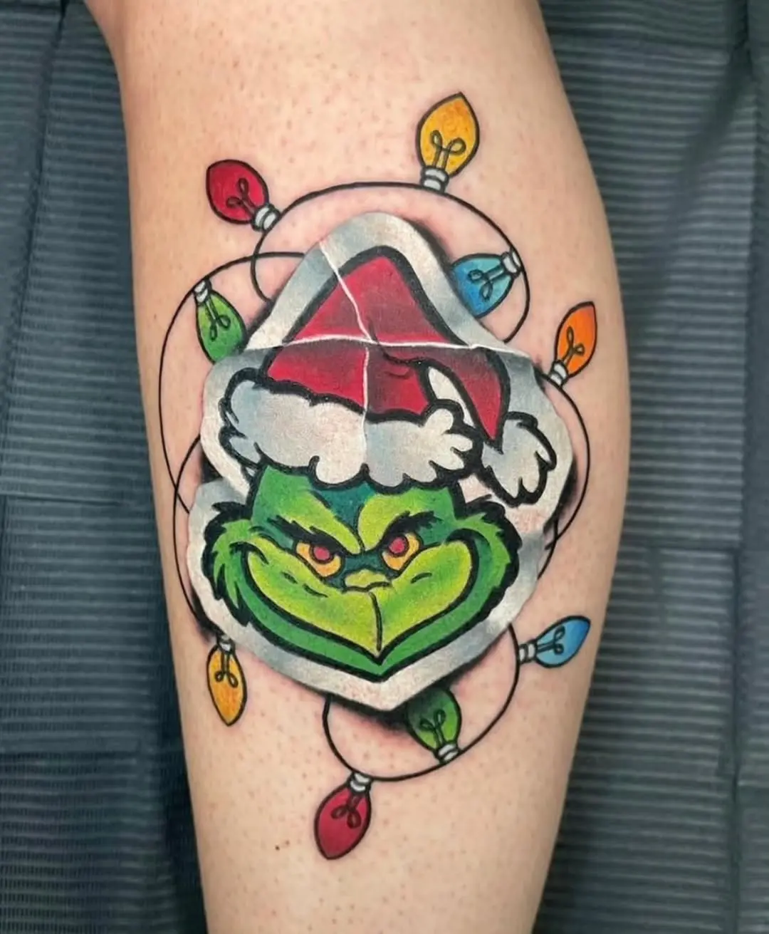 Playful Grinch Tattoo Surrounded by Colorful Lights