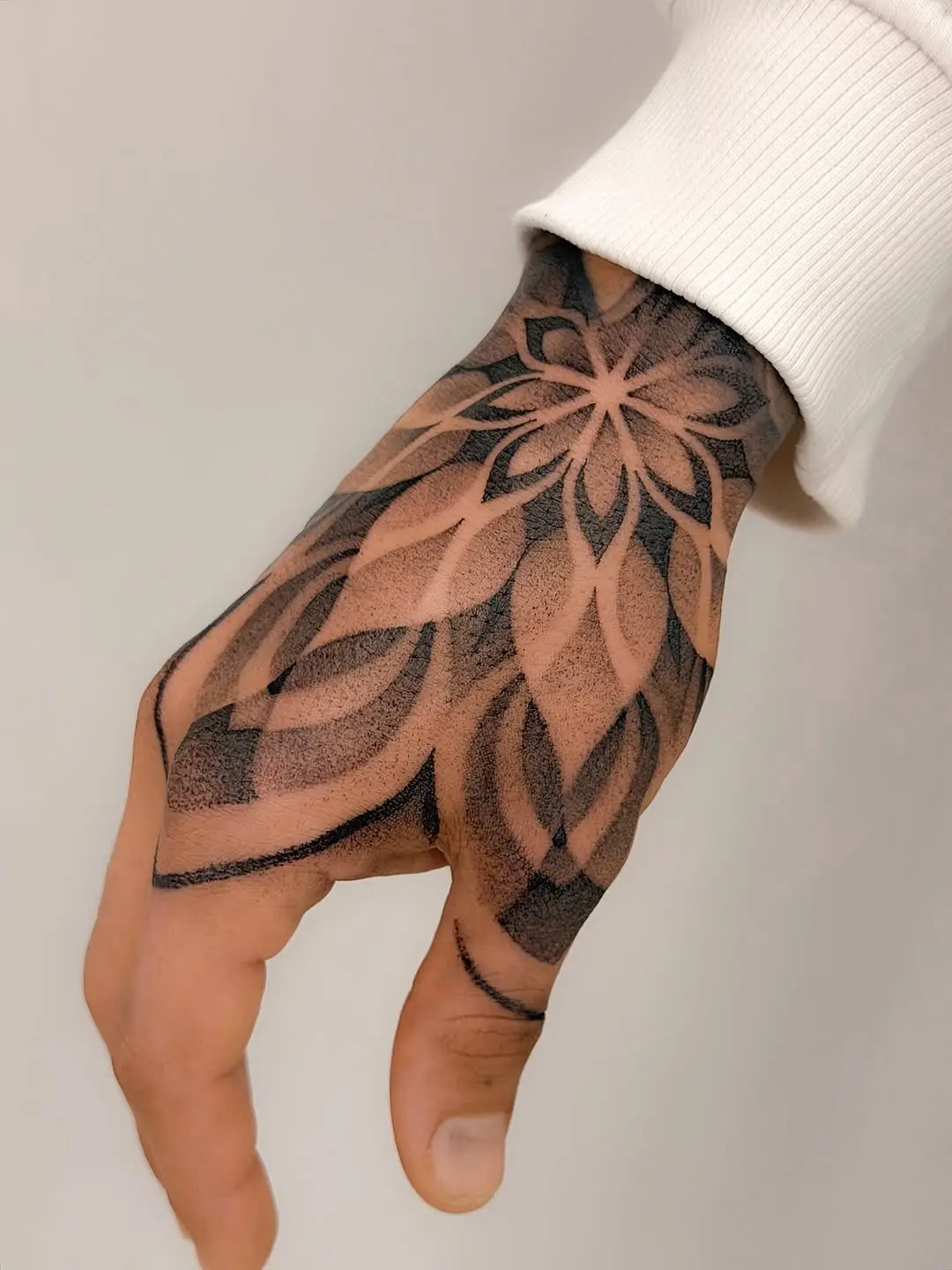 Intricate floral dotwork tattoo on hand