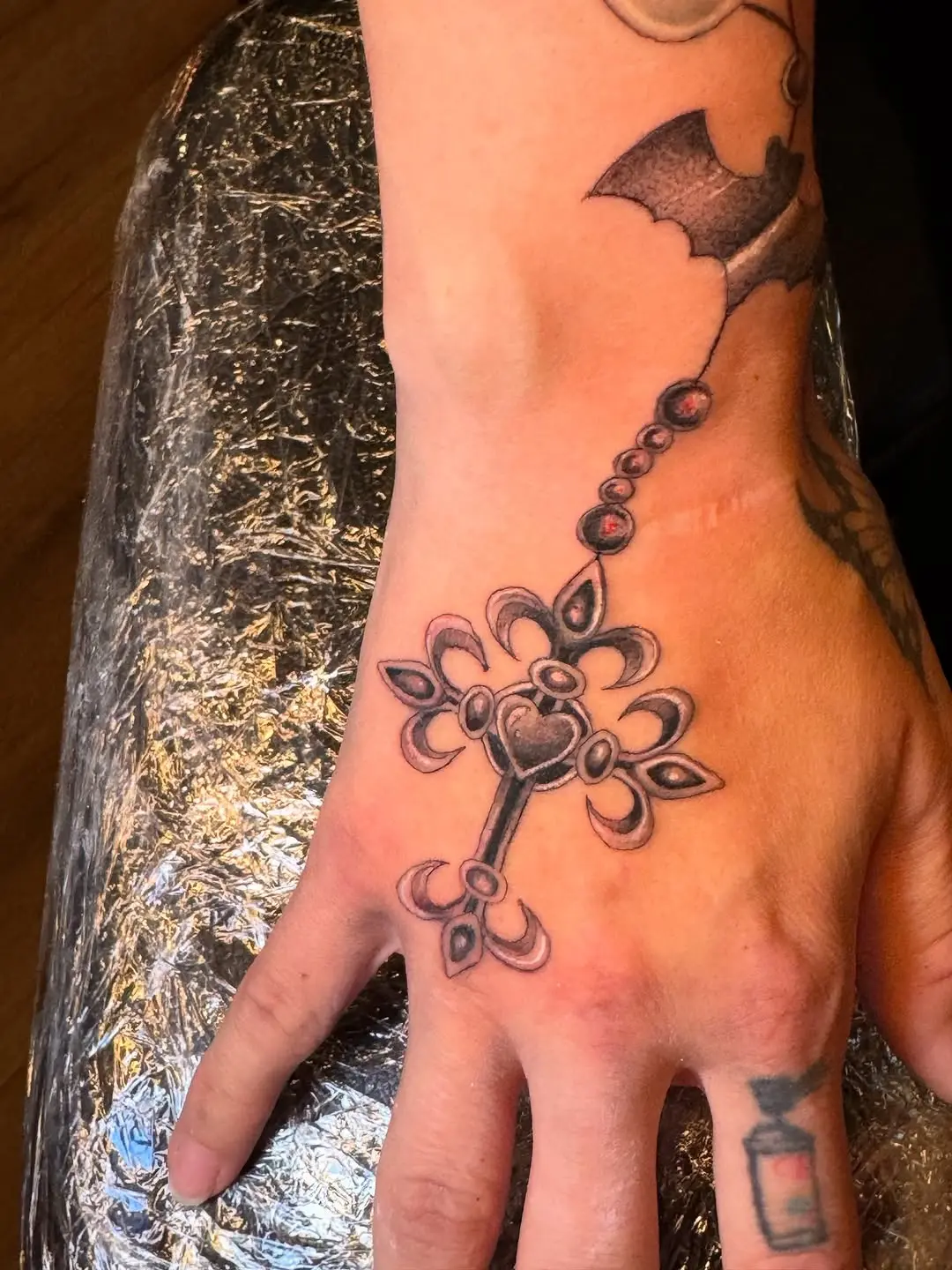 Intricate rosary design adorns the hand