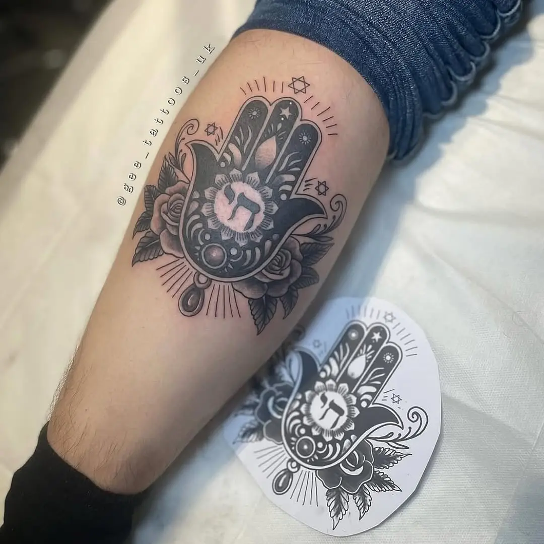 Symbolic Hebrew hand tattoo with floral details