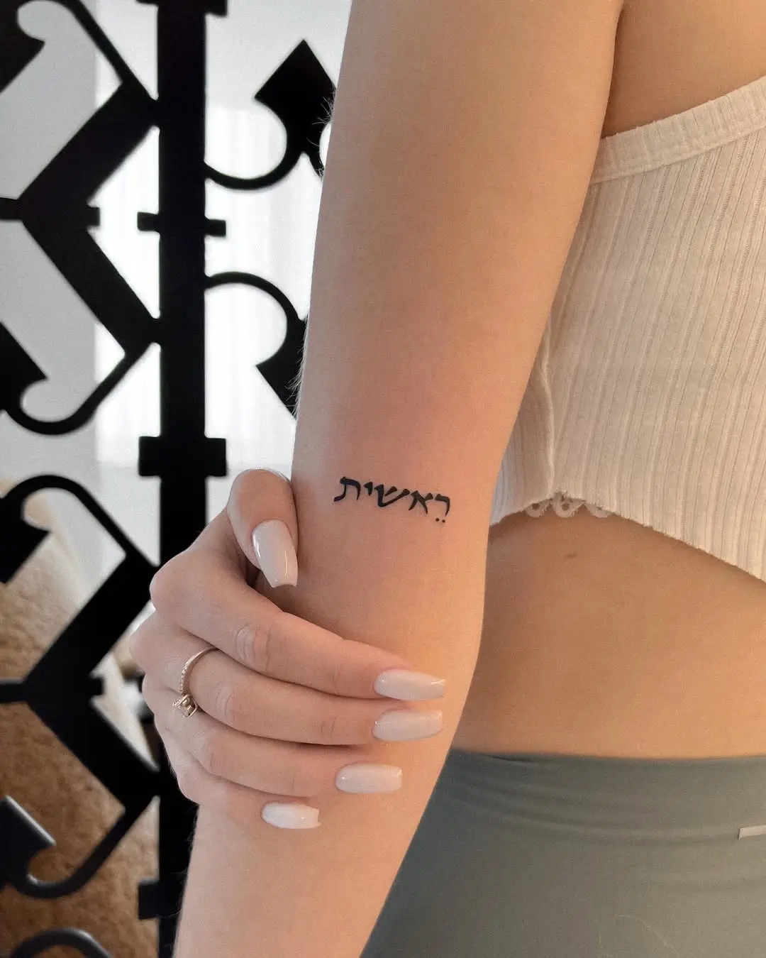 Elegant Hebrew Script Tattoo on Arm