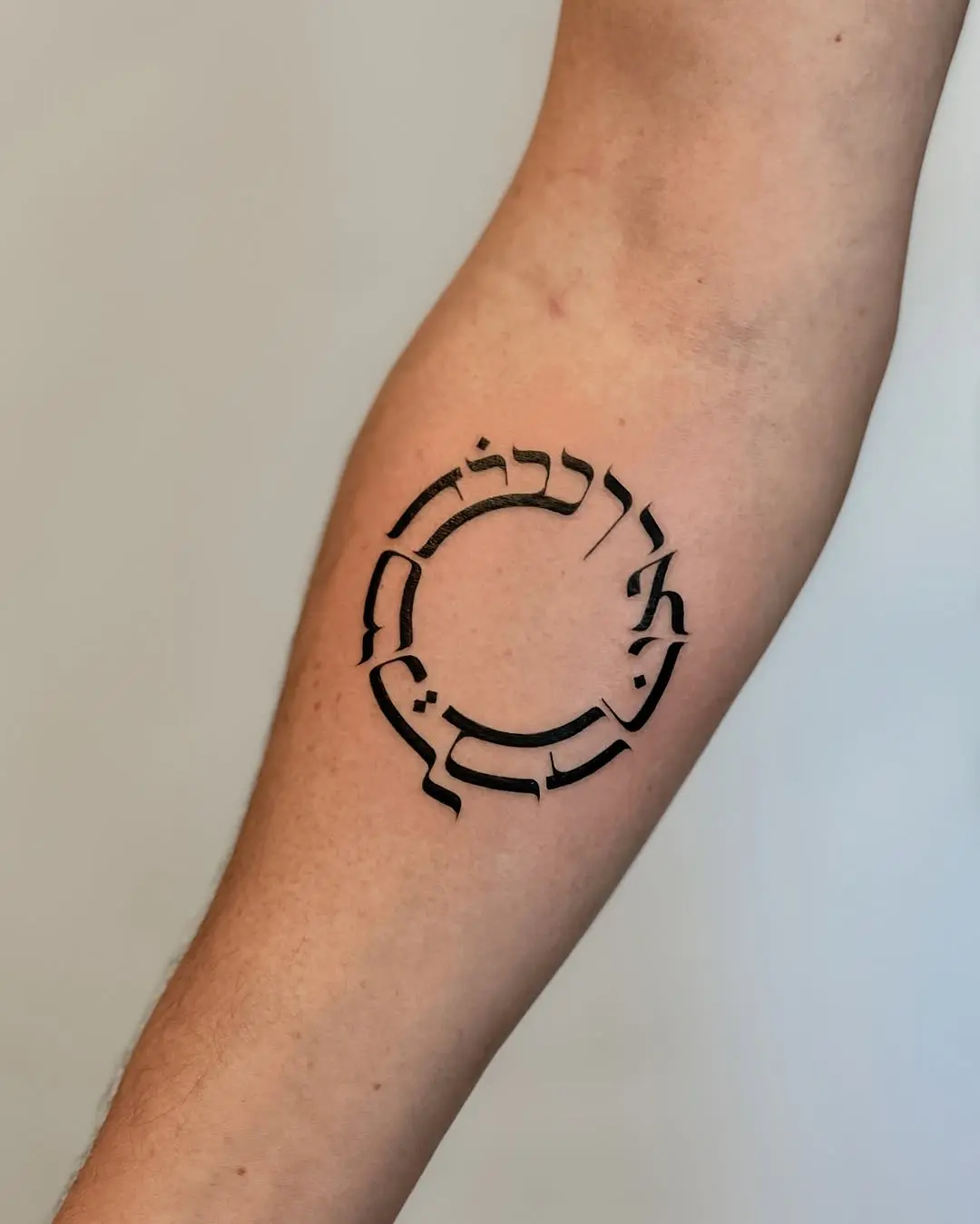 Circular Hebrew Tattoo Design with Modern Aesthetic
