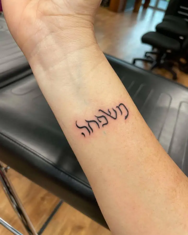 Elegant Hebrew Script Tattoo on Forearm