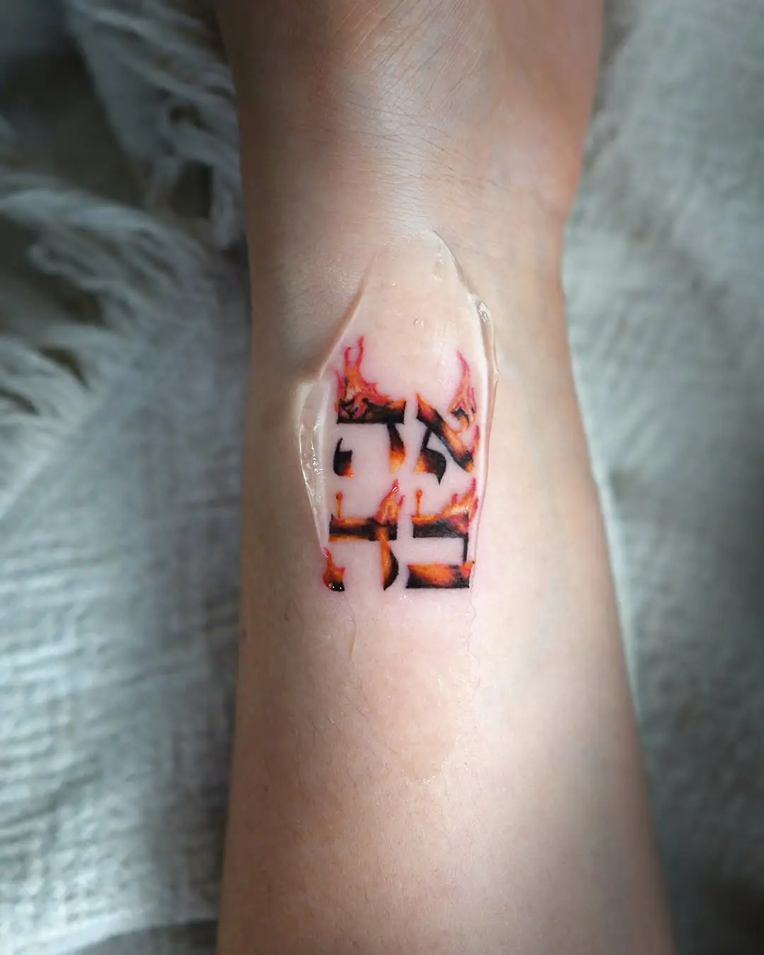 Artistic Hebrew tattoo on forearm