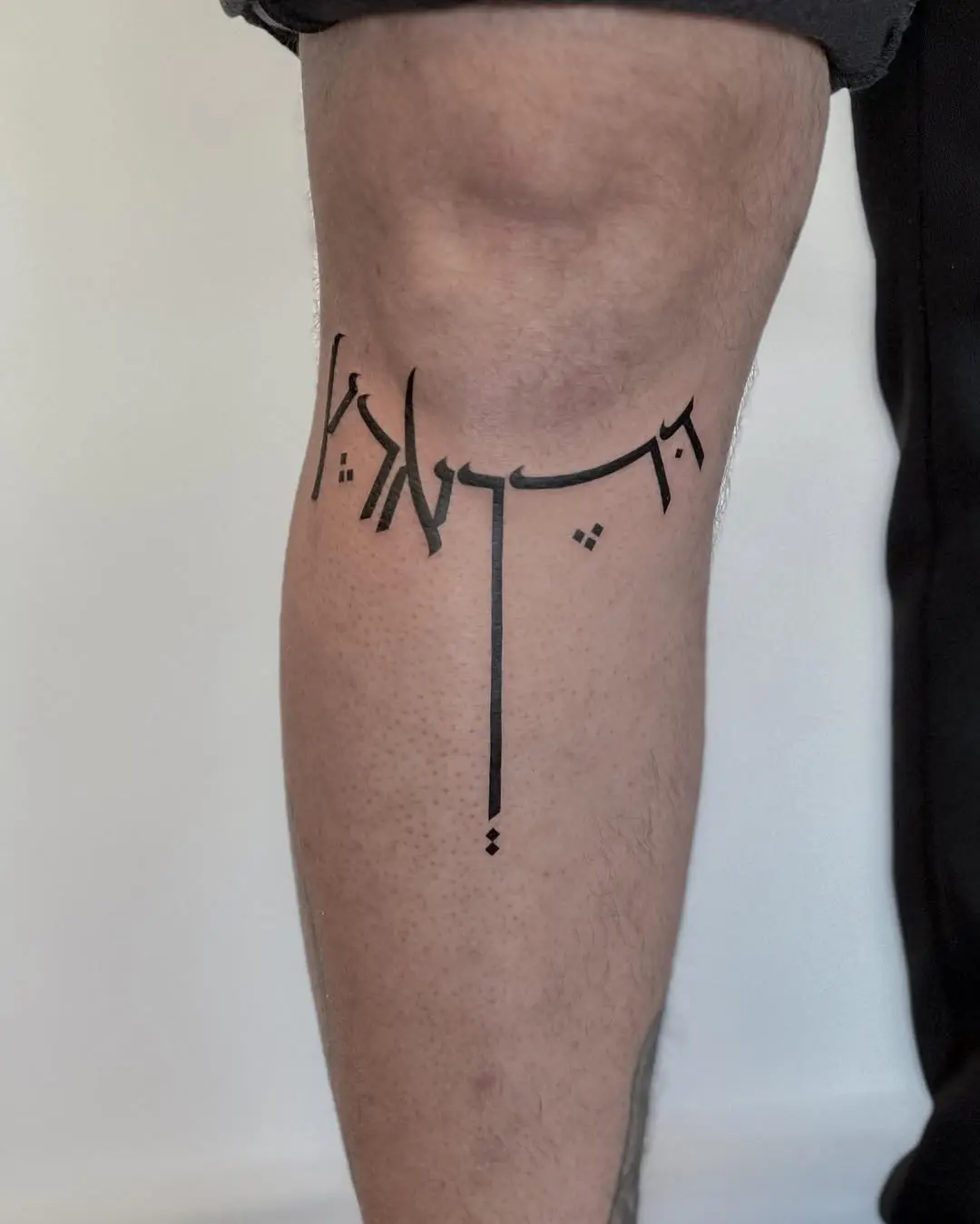 Elegant Hebrew Script Tattoo on the Leg