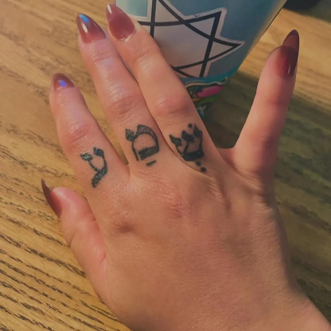 Elegant Hebrew Tattoos on Delicate Fingers