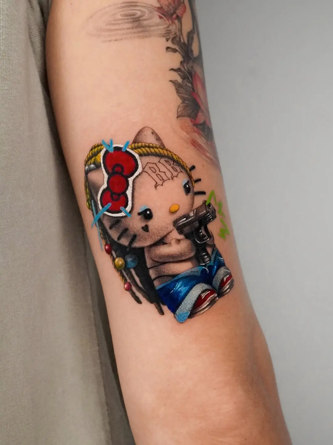 Vibrant Hello Kitty with a Gun Tattoo