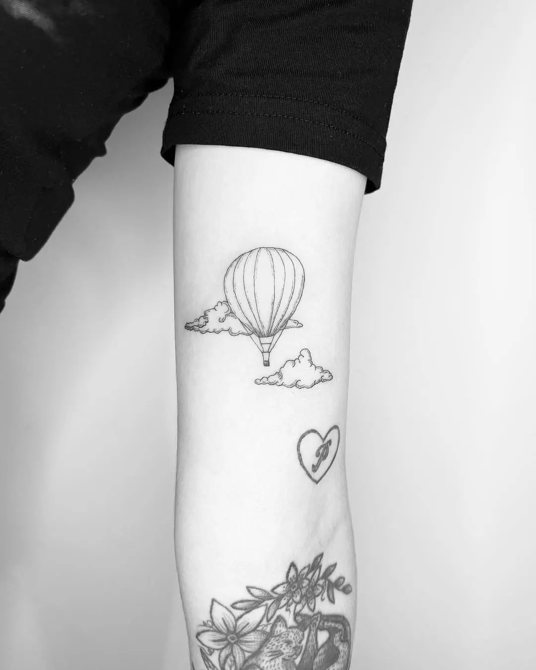Minimalist hot air balloon tattoo with clouds