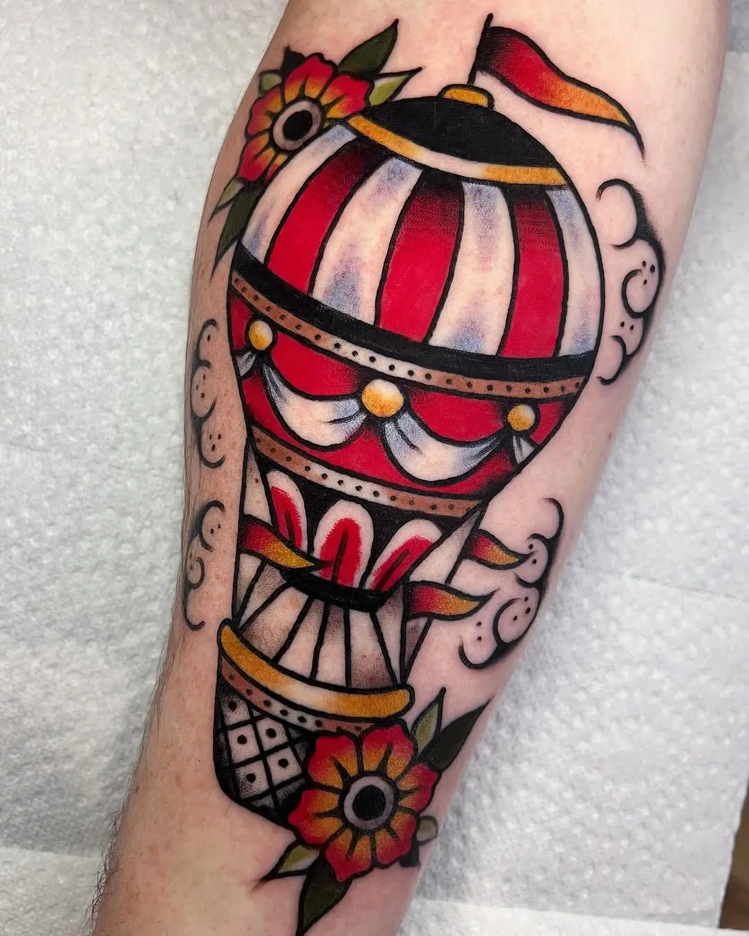 Vivid hot air balloon tattoo with floral accents