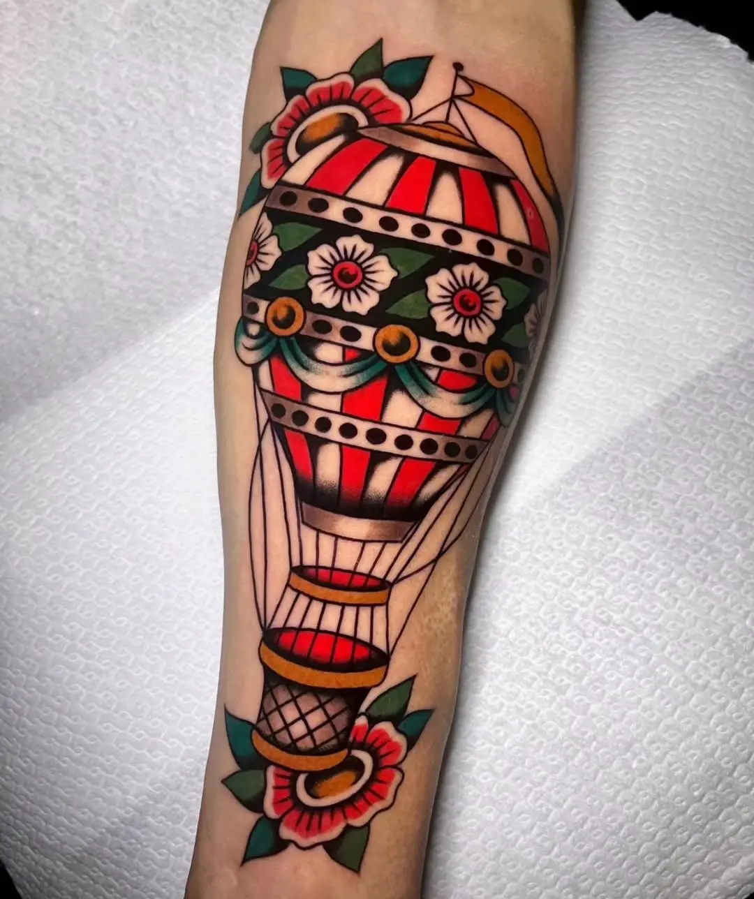 Colorful hot air balloon tattoo with floral accents
