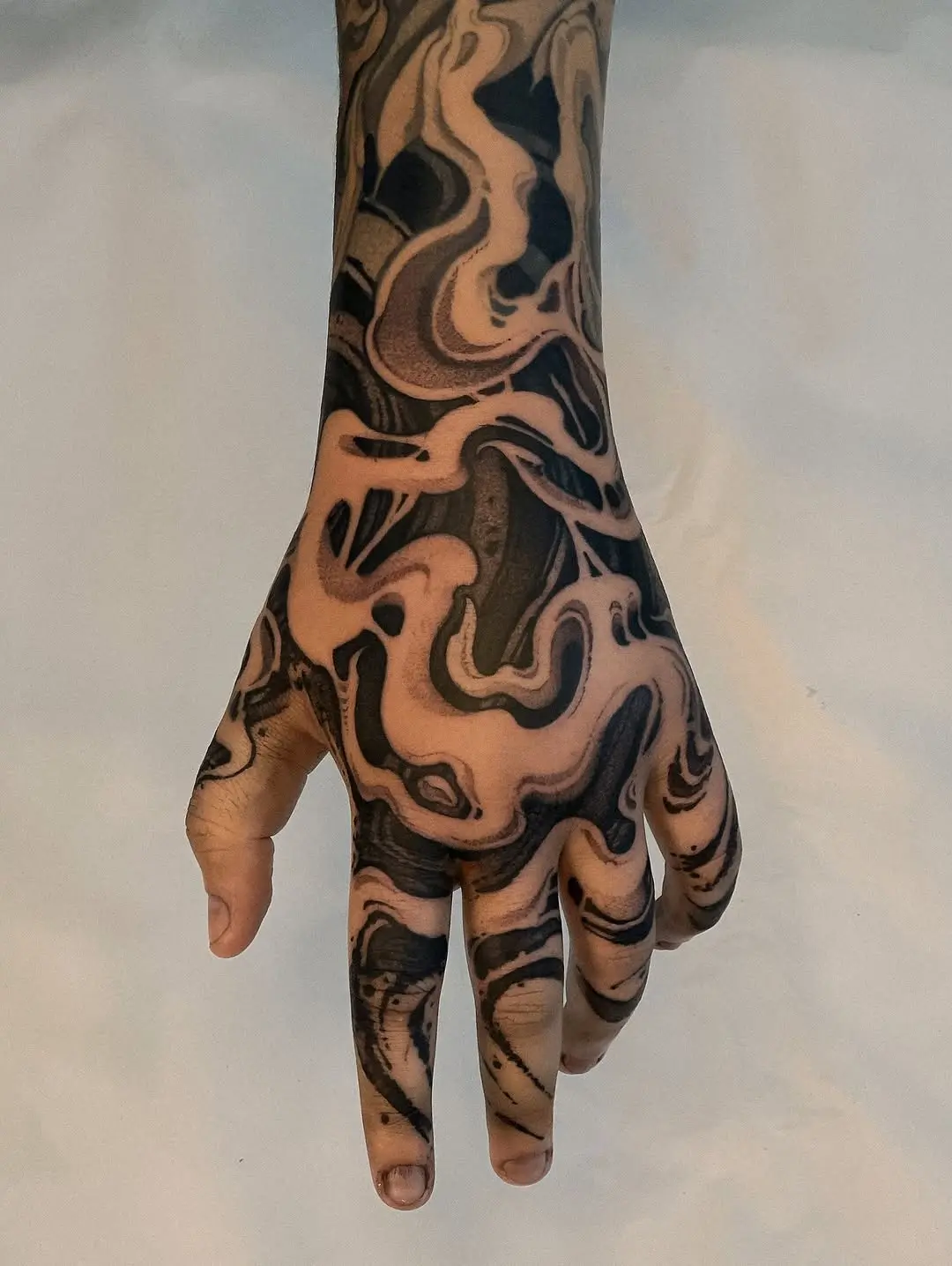 Elegant swirls in dotwork tattoo on hand