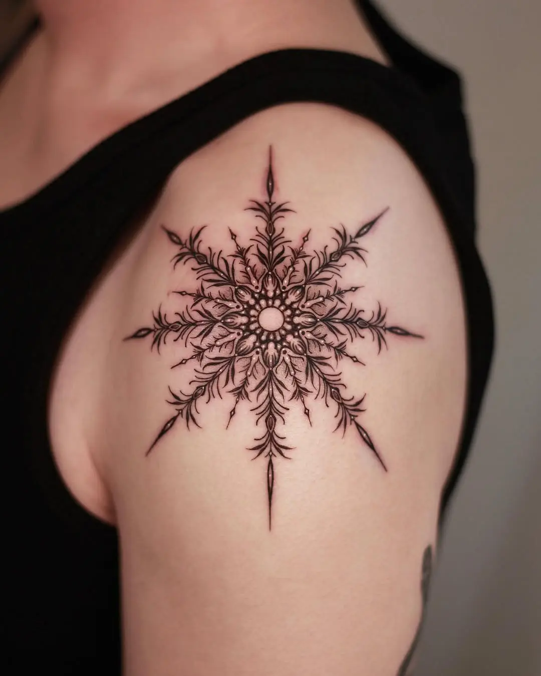 Intricate black ink snowflake tattoo design