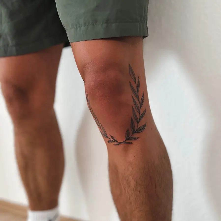 Stylish laurel wreath tattoo on a knee