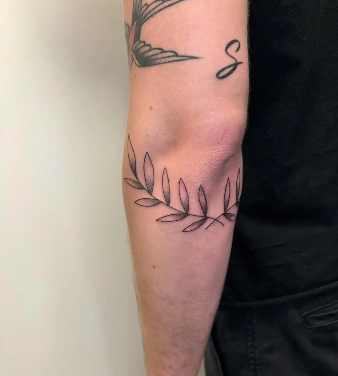 Elegant laurel wreath tattoo on the forearm