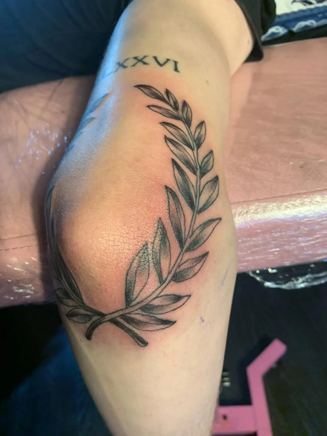 Elegant laurel wreath design on the arm.