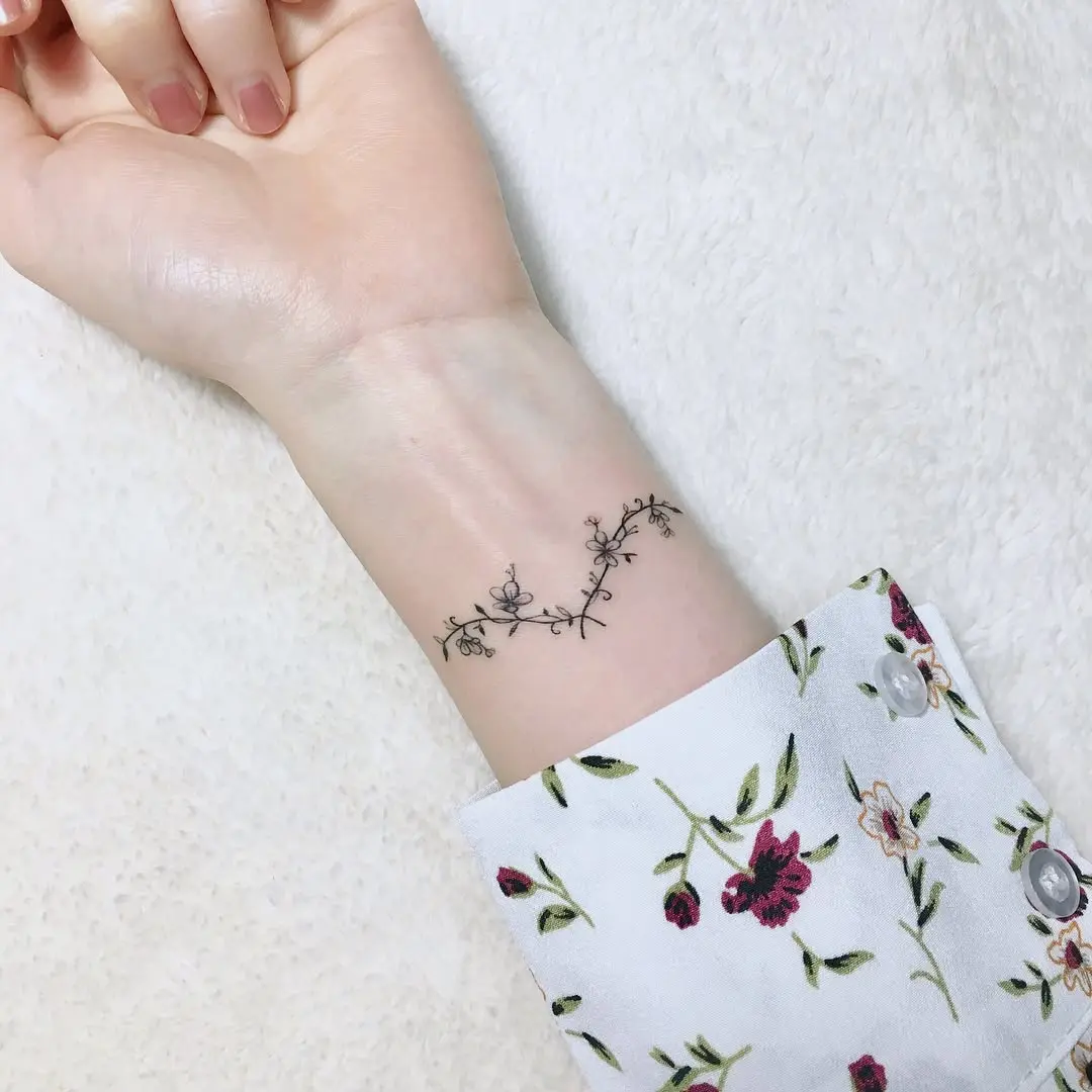 Elegant floral laurel wreath tattoo on wrist