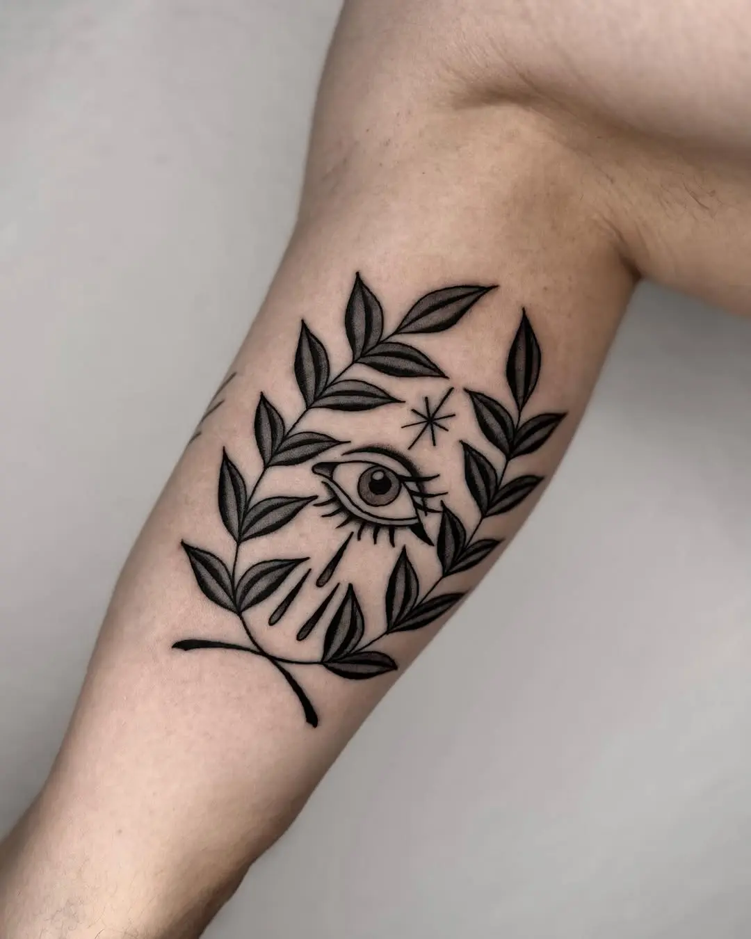 Stylish laurel wreath tattoo with an eye design