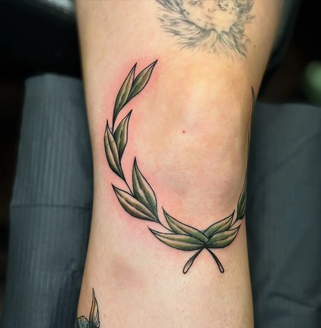Elegant laurel wreath inked on the knee