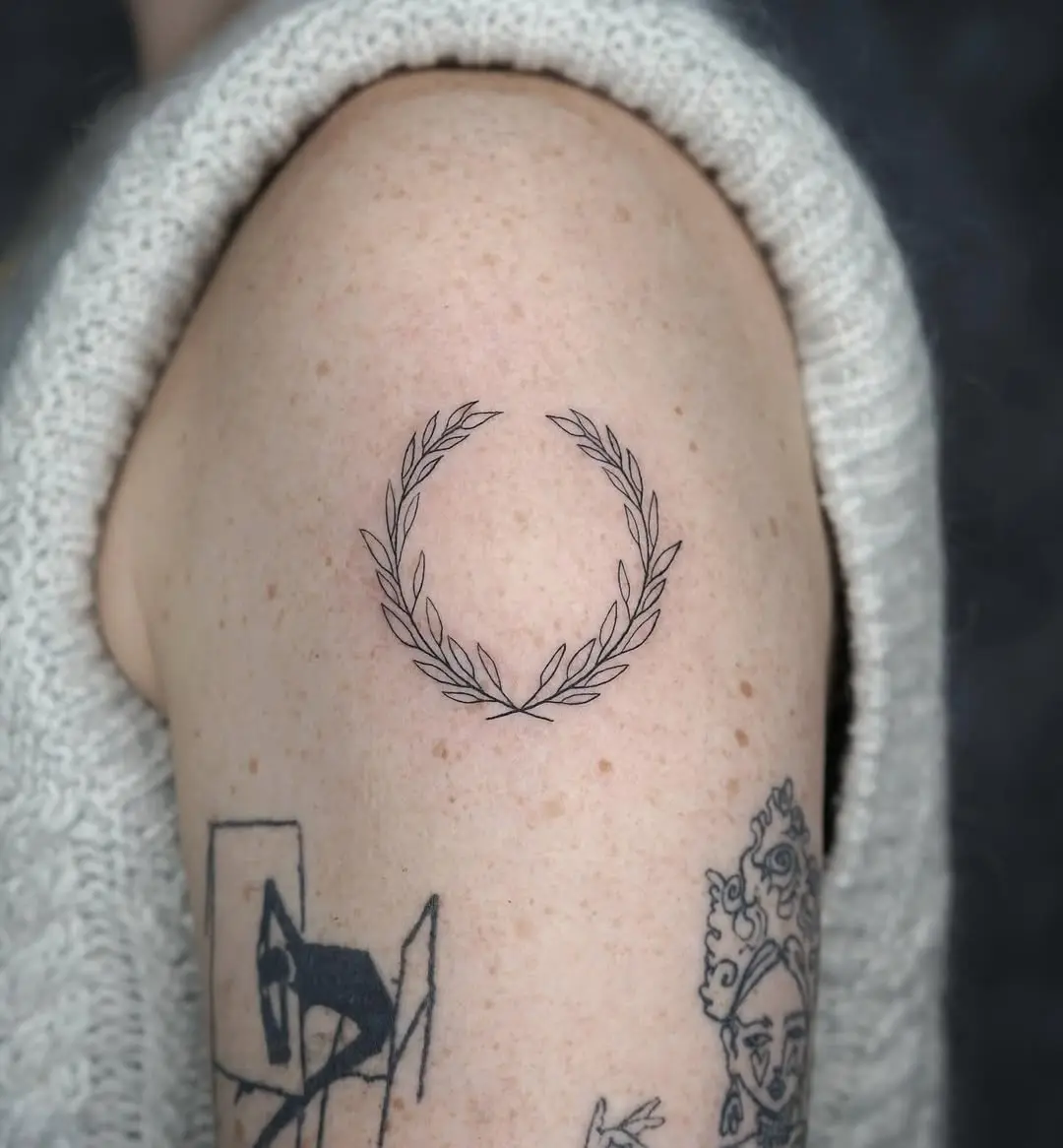Minimalist laurel wreath tattoo on the arm