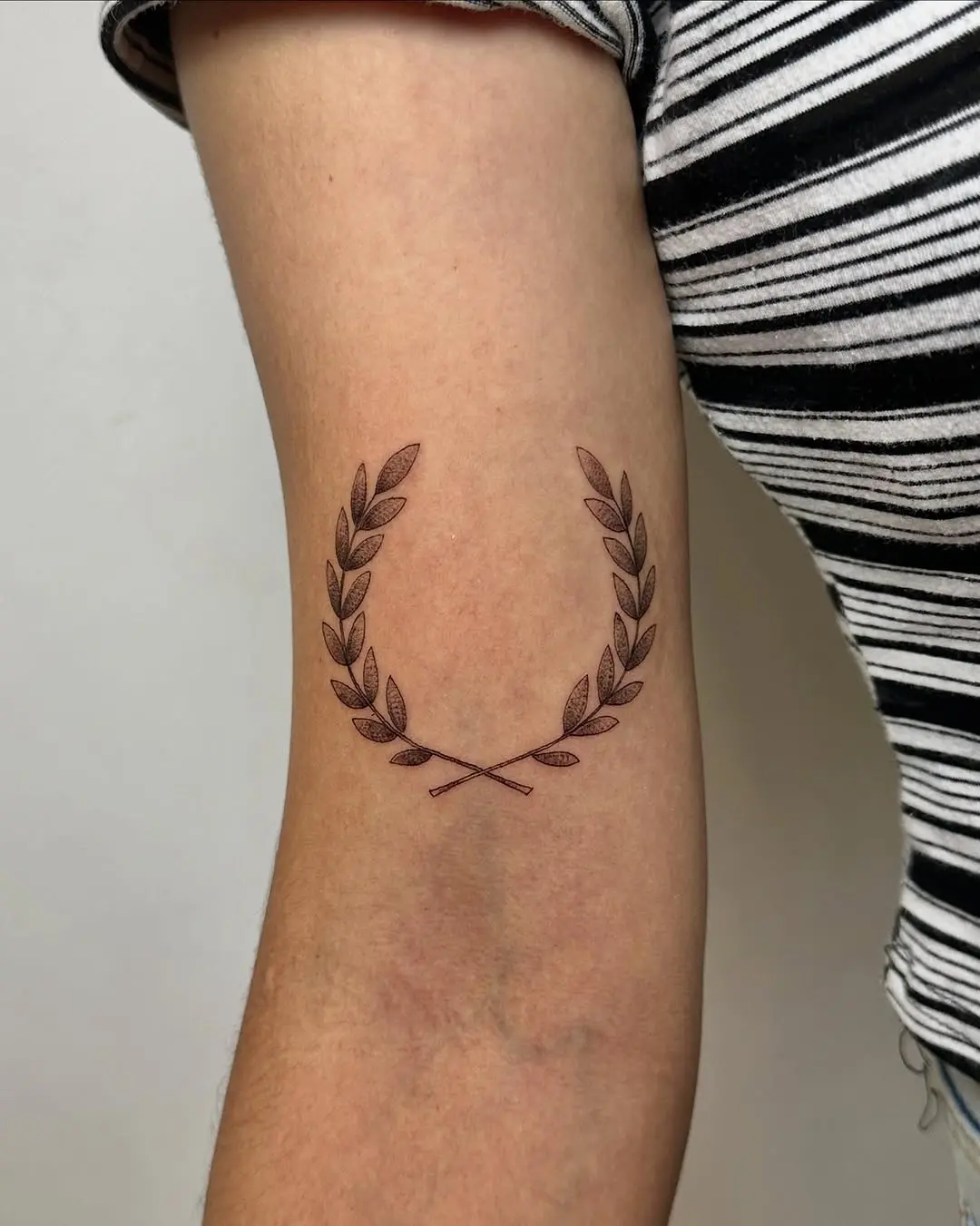 Elegant laurel wreath tattoo on upper arm