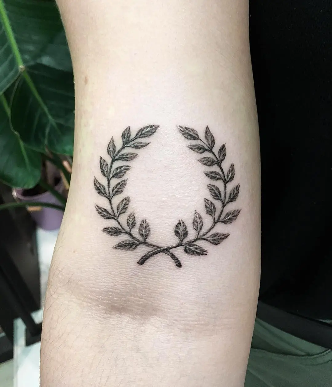 Elegant laurel wreath tattoo with intricate details