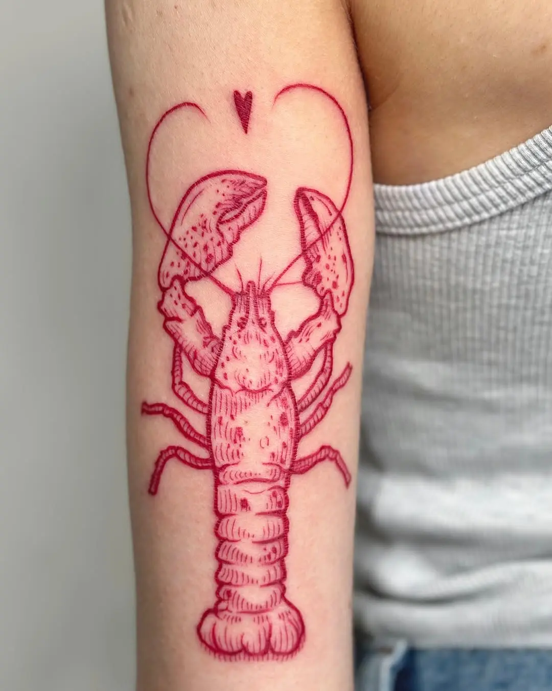 Whimsical lobster tattoo with a love twist