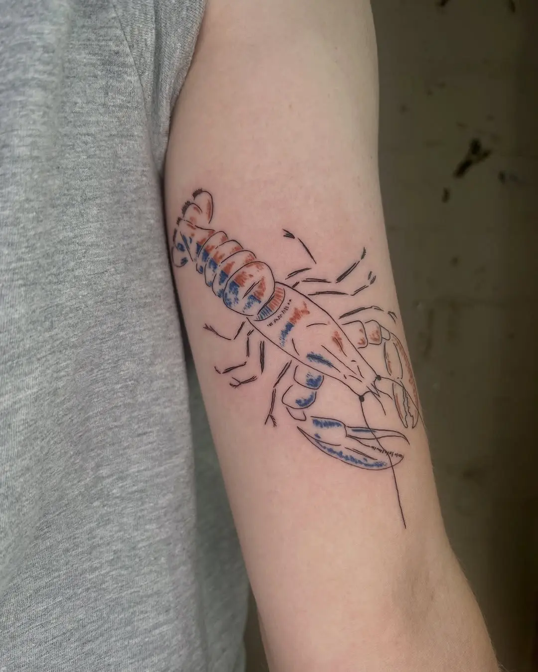 Colorful lobster tattoo on bare arm