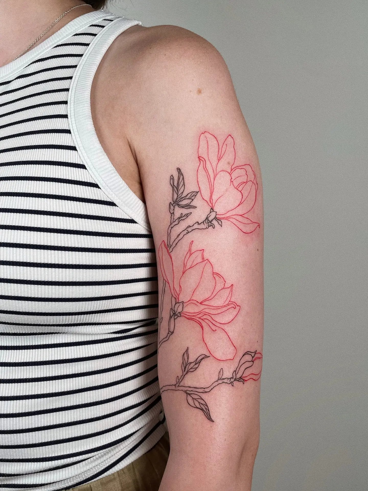 Delicate outline magnolia tattoo on arm