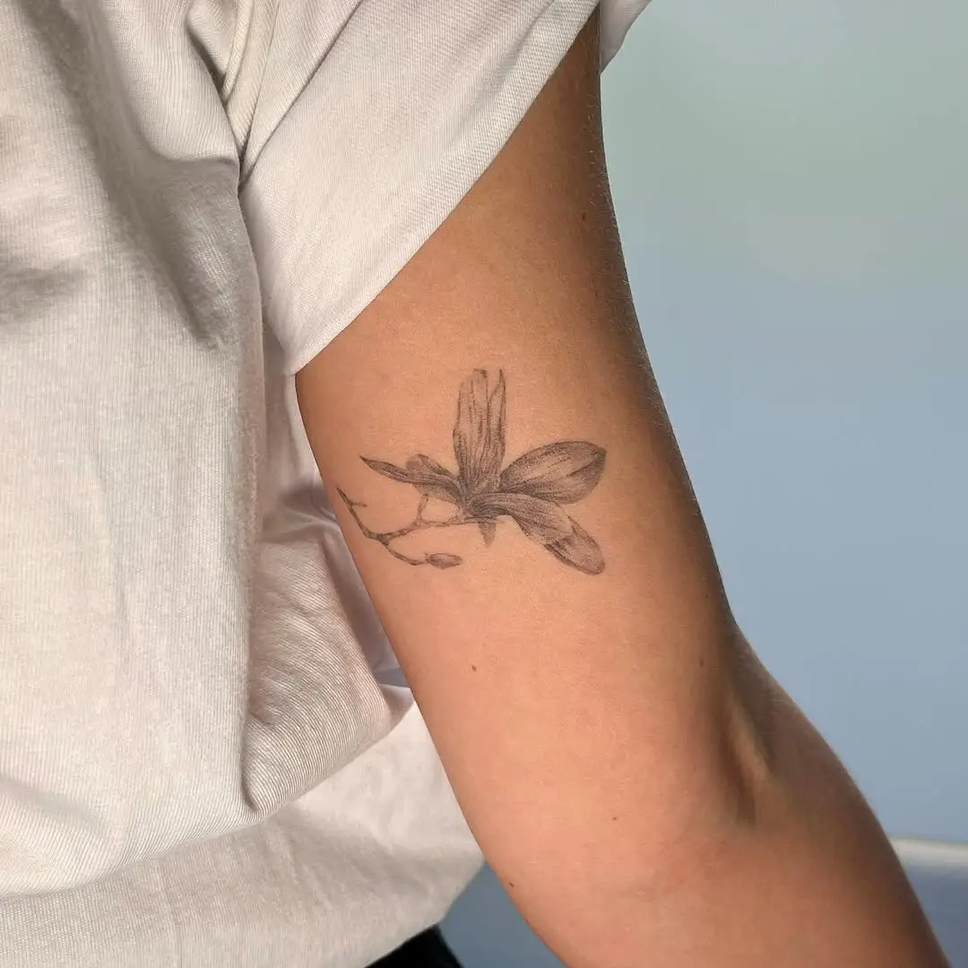 Elegant magnolia tattoo on a relaxed arm.