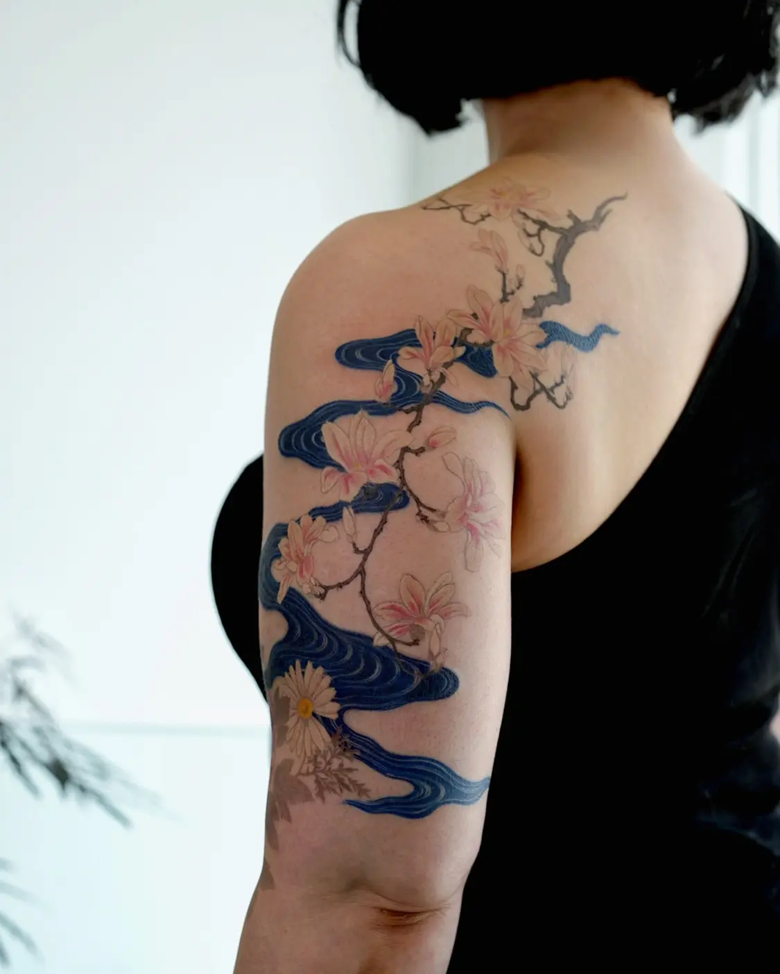 Elegant magnolia tattoo with flowing waves