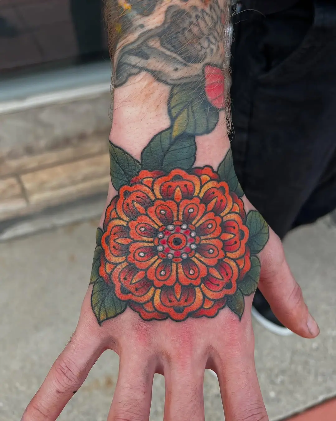 Bold marigold tattoo on hand showcases beauty