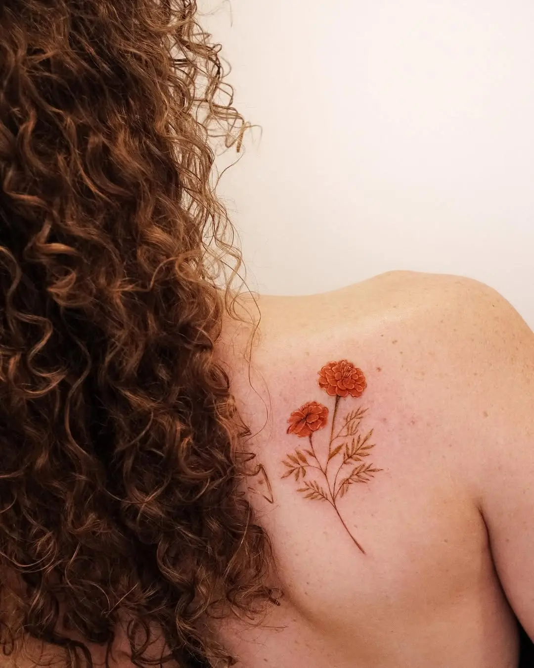 Elegant marigold tattoo on shoulder area