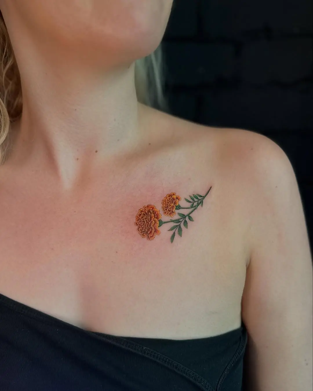Vibrant marigold tattoo on shoulder area