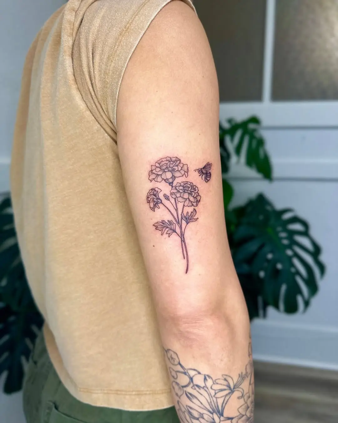 Elegant marigold tattoo with delicate bee
