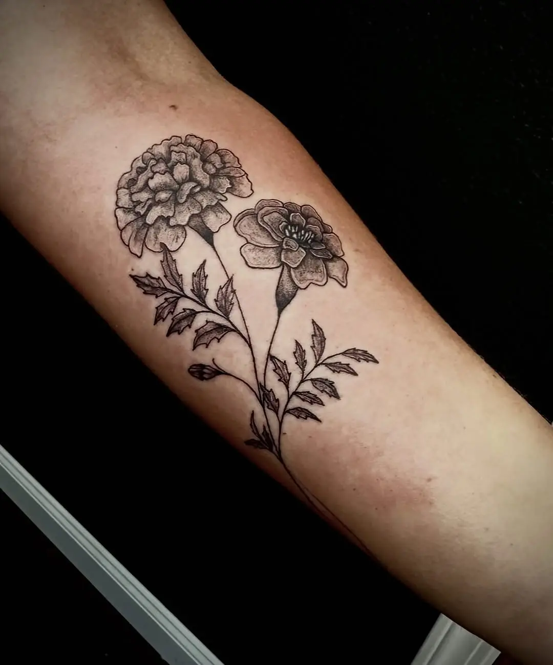 Elegant marigold tattoo design in black ink