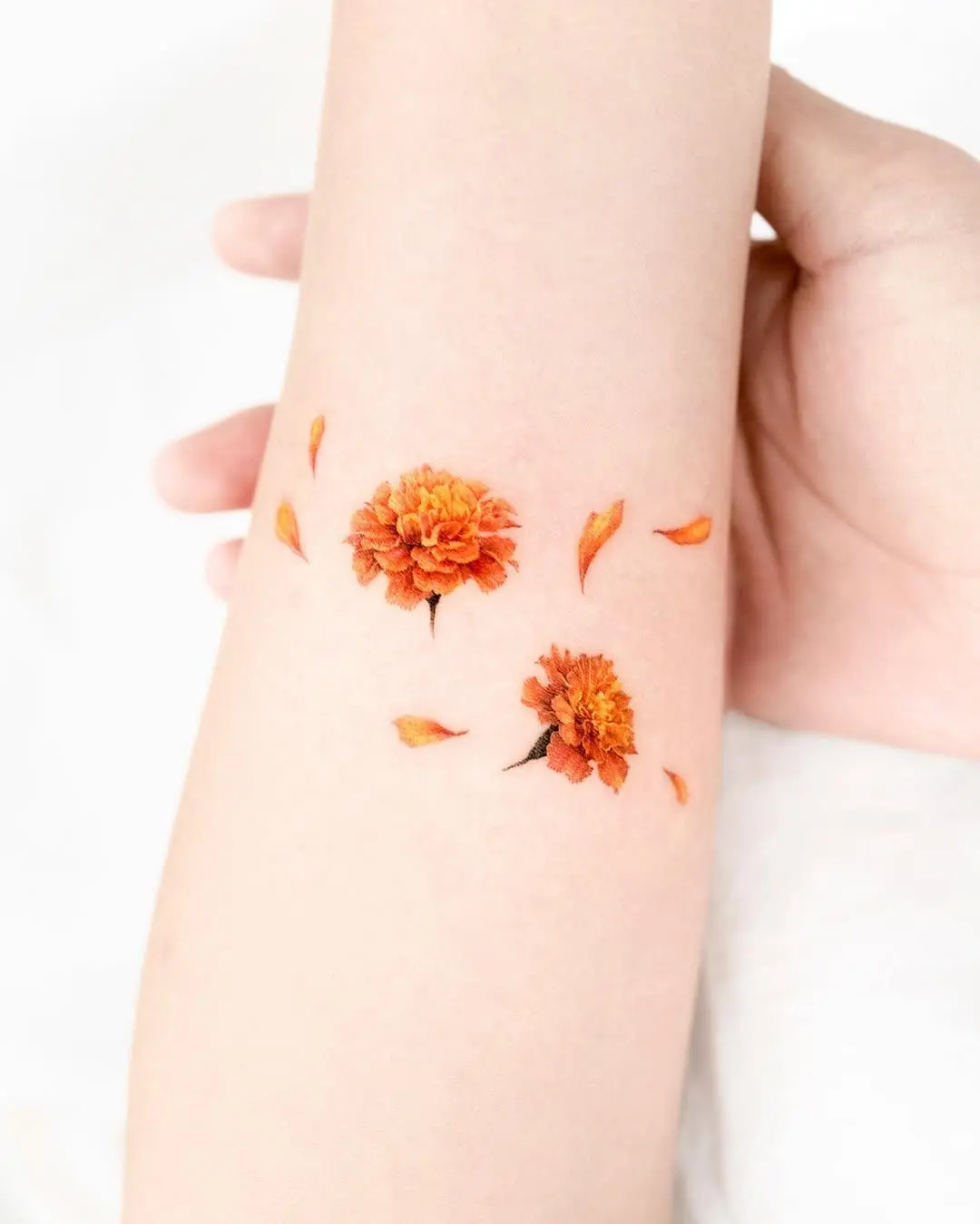 Vibrant marigold tattoo with delicate petals.