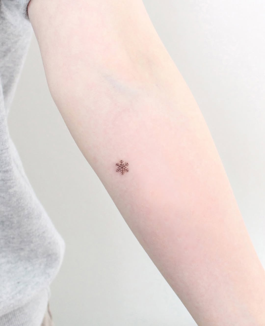 Elegant snowflake tattoo on the forearm