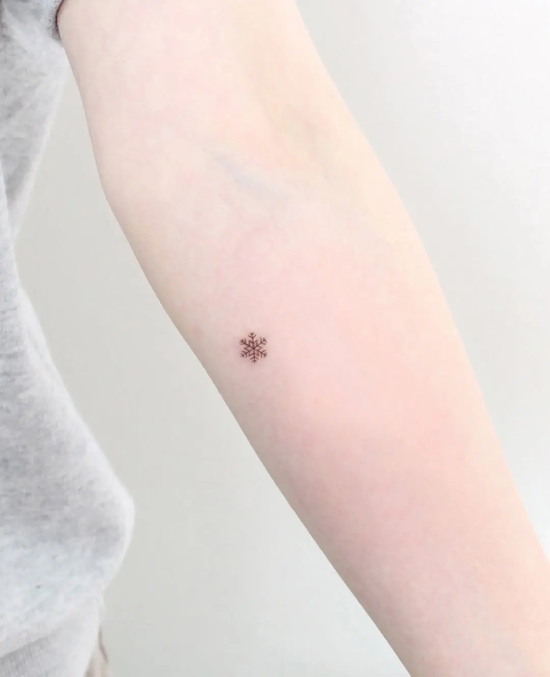 Elegant snowflake tattoo on the forearm