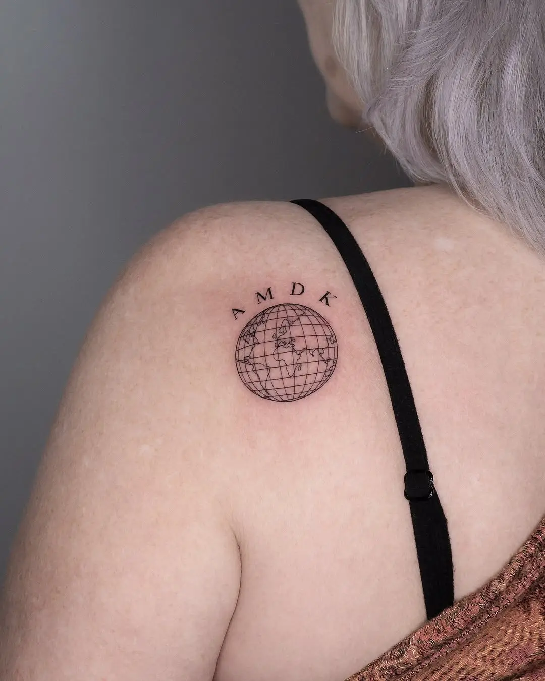 Elegant globe tattoo radiating wanderlust vibes