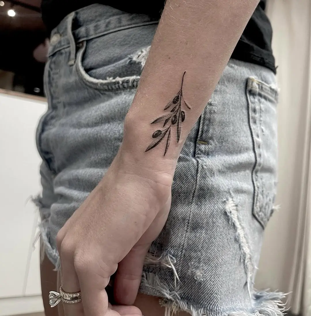 Stylish olive branch tattoo on the forearm