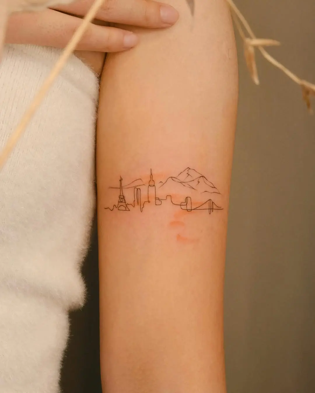 Elegant minimalist skyline tattoo with iconic landmarks