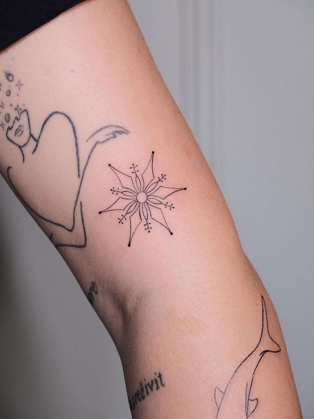 Minimalist snowflake tattoo showcases elegant design
