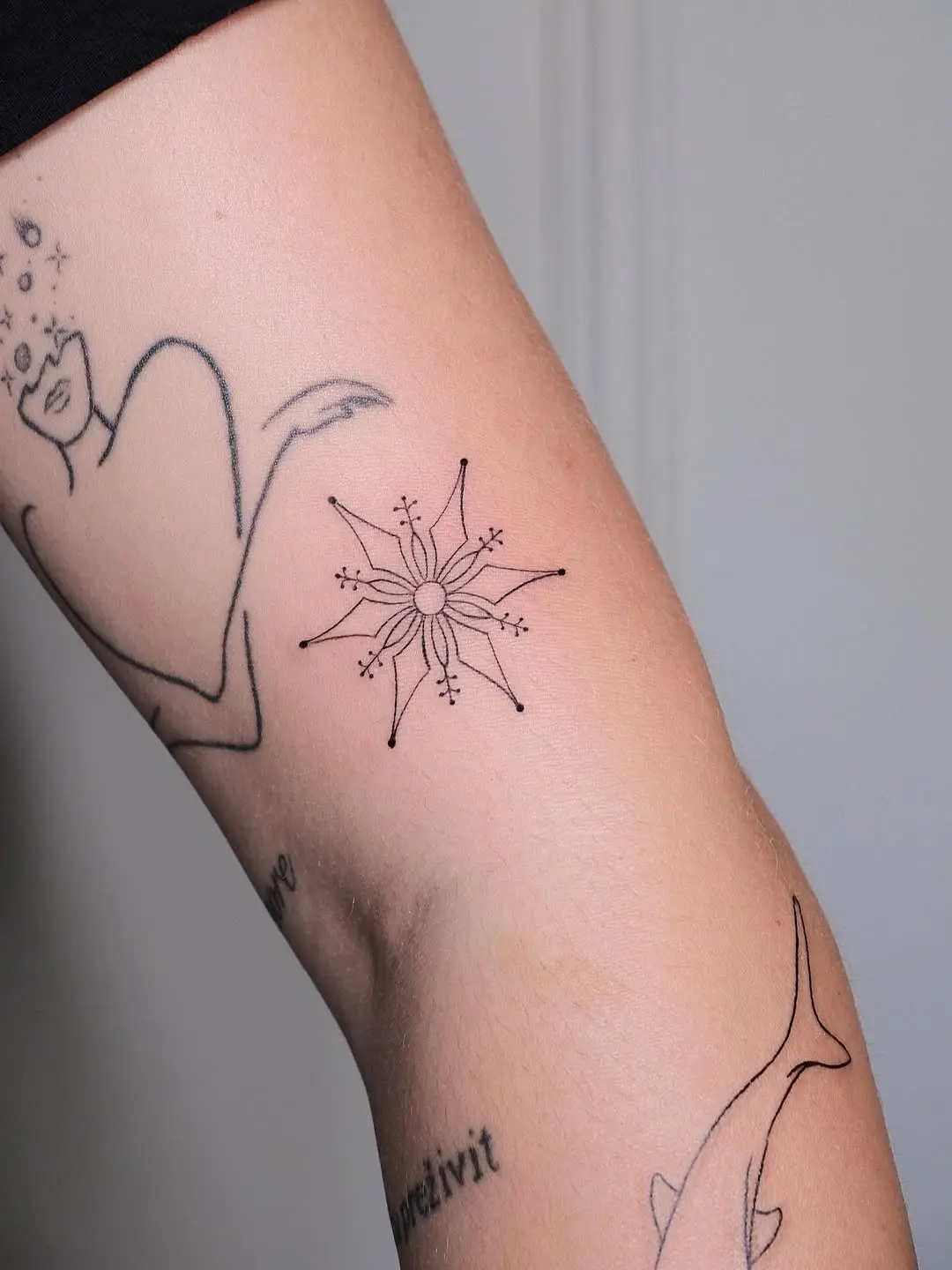 Minimalist snowflake tattoo showcases elegant design