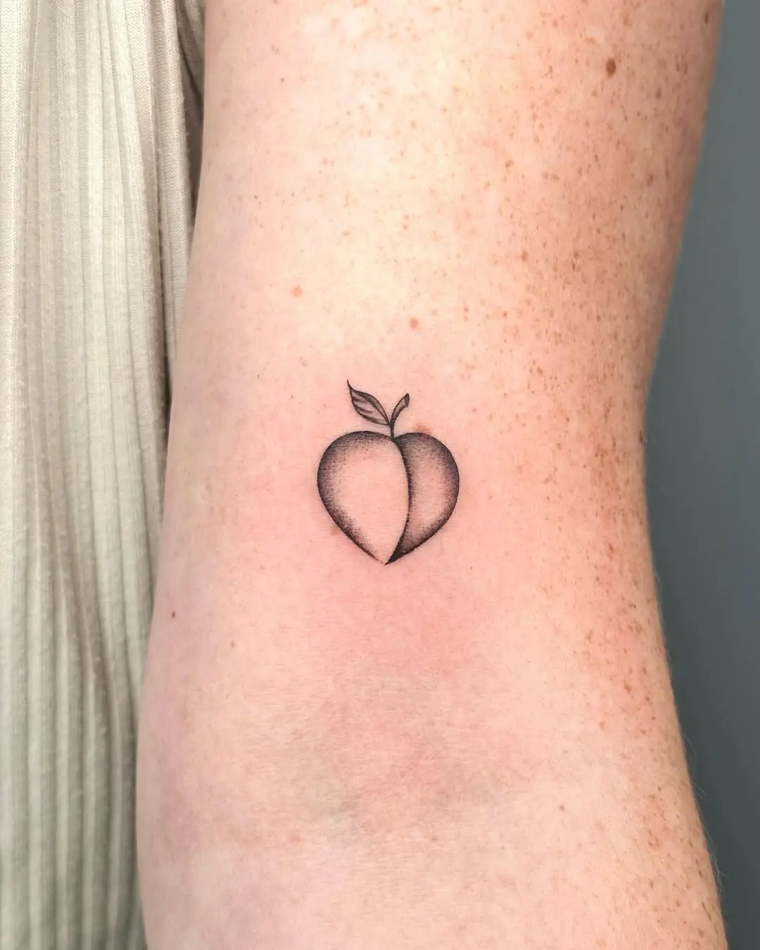 Minimalist peach tattoo with subtle detailing