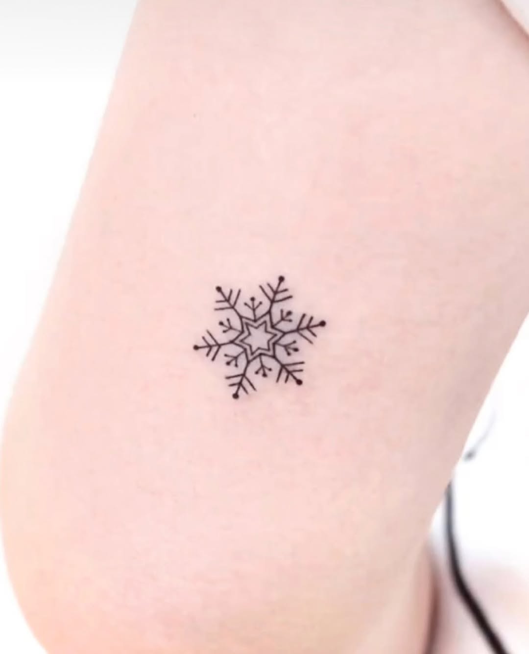 Charming minimalistic snowflake tattoo design