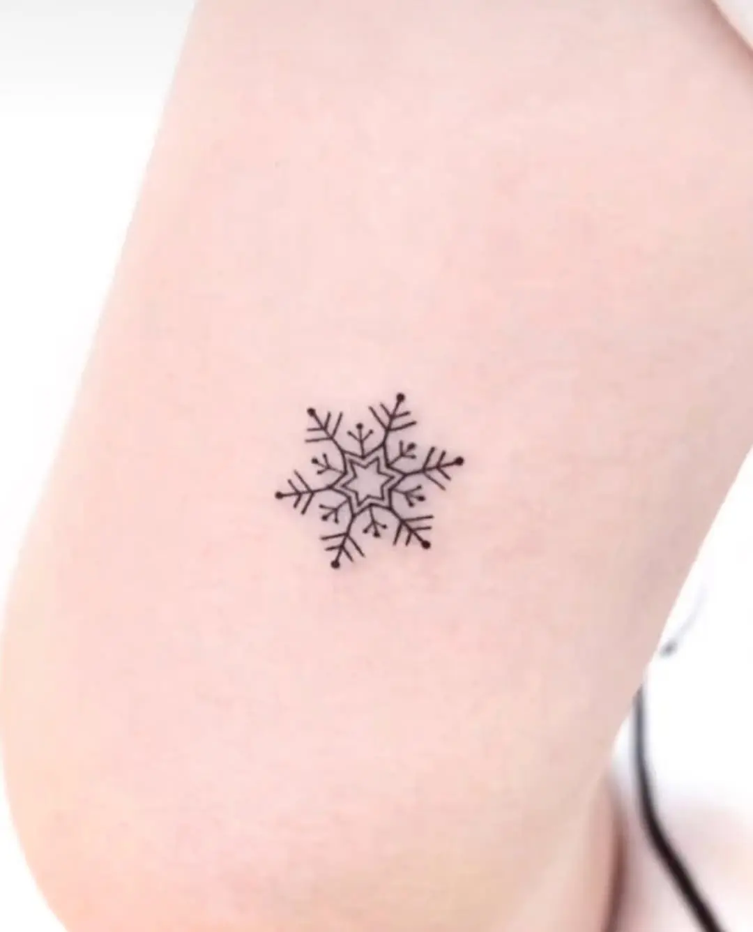 Charming minimalistic snowflake tattoo design